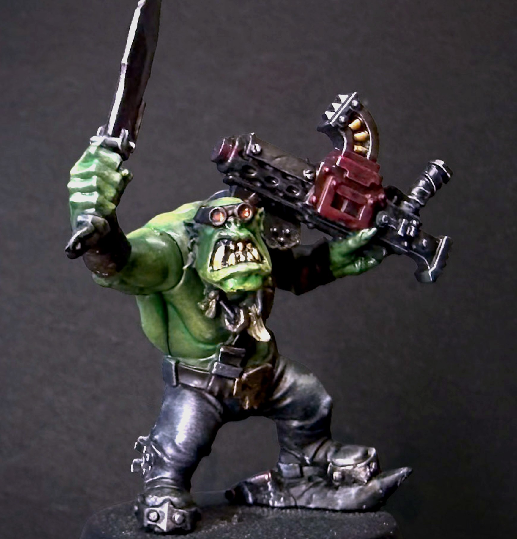 Painted Ork Boy with goggles, a raised sword and combi weapon